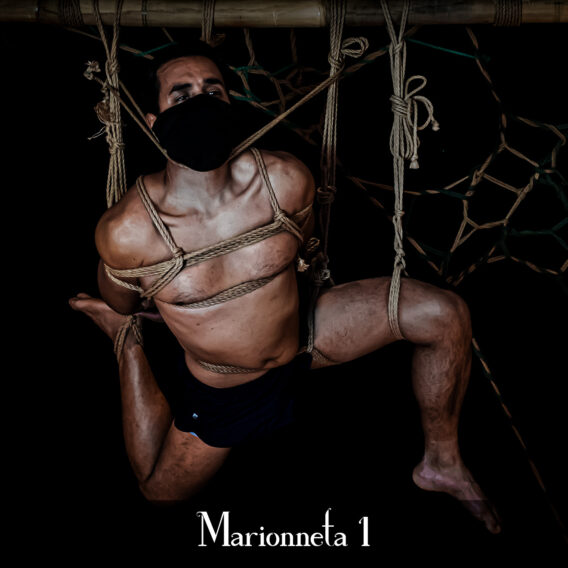 Un homme est suspendu par des cordes de shibari, il semble disloqué comme une marionnette.